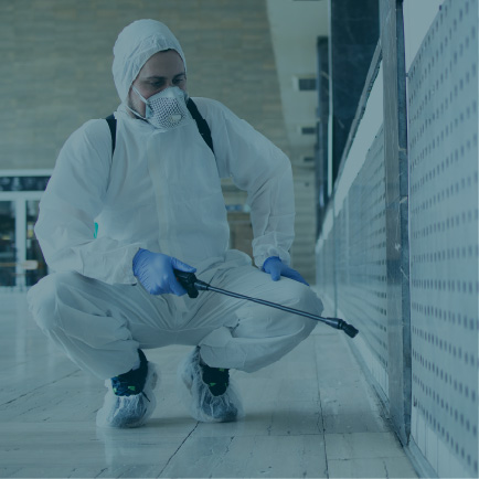 Man spray painting a wall in a full PPE suit